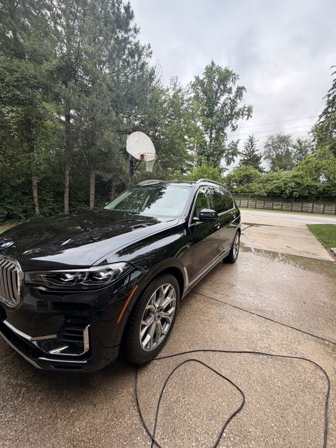 Black BMW X7 washed and dried in a driveway